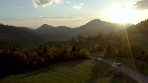 Scenic Mountain Landscape at Sunset with Cars
