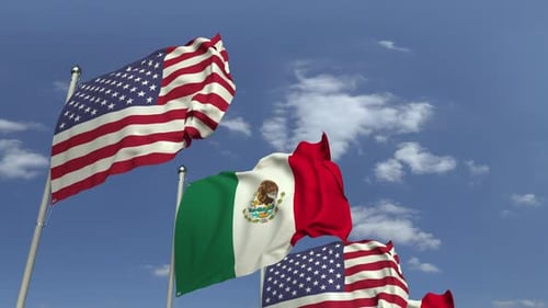 US and Mexico National Flags Waving Against Blue Sky