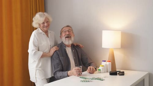 Loving Elderly Couple with Medicine at Home