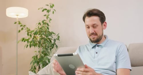 Man Relaxing at Home Using a Tablet