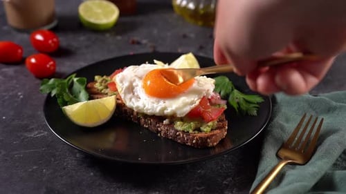 Breaking Yolk on Avocado Toast for Delicious Brunch
