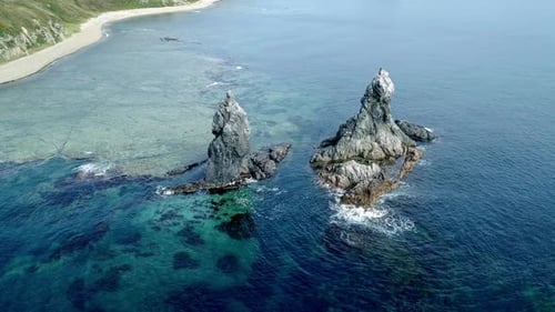 Aerial High Angle View of High Sea Stacks High Rocky Cliff Pillars and Transparent Turquoise Sea