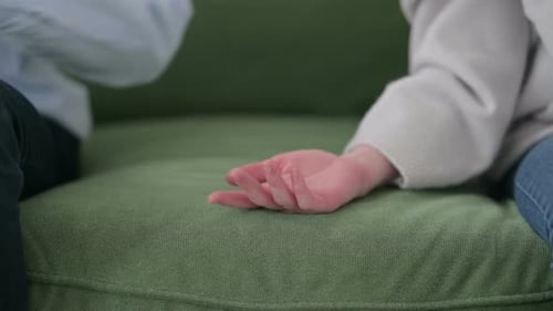 Close Up of Mixed Race Couple Holding Hands on Sofa