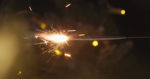 Golden Sparkler Emitting Light and Sparks at Night