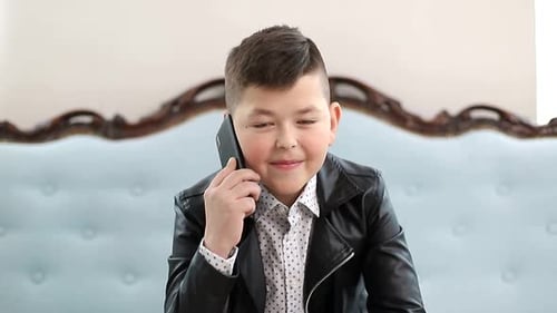 Smiling Boy Talking on a Cellphone Indoors
