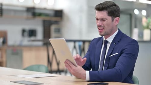 Man Frustrated Using Tablet in Office Workplace