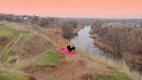 Jeune femme faisant du yoga dans un paysage calme