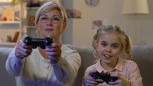 Grandmother and Granddaughter Playing Video Games at Home