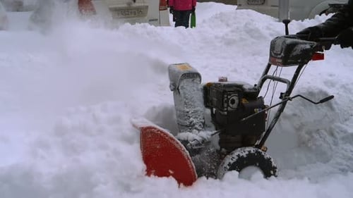 Man with a Snow Blowing Machine Working