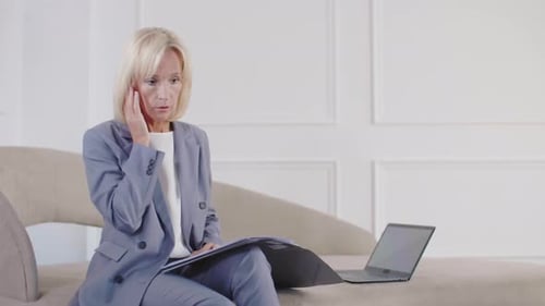 Middle-aged Female Company Director Using Wireless Earphones