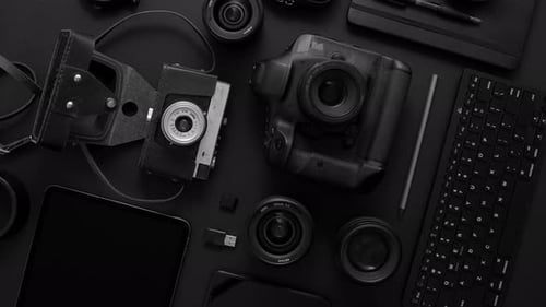 Conceito de espaço de trabalho do fotógrafo. Vários dispositivos digitais e analógicos colocados em fundo preto