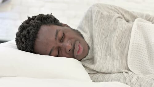 Afrikanischer Mann hat Kopfschmerzen im Schlaf