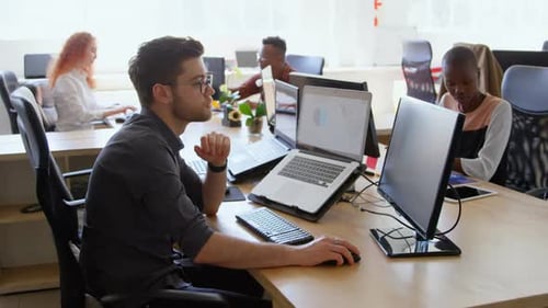 Side view of young cool mixed-race business team working at desk in a modern office 4k