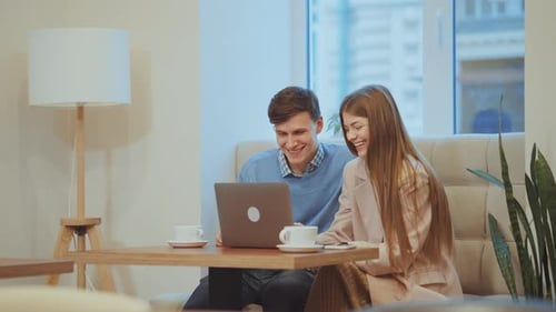 Happy Couple Sitting in Cafe and Using Laptop