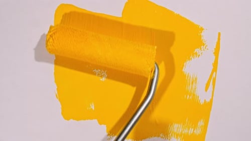 Bright Yellow Paint Roller Applying Paint
