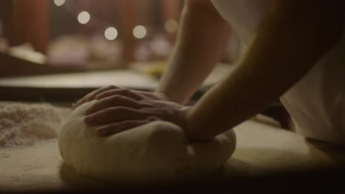 Baker Kneading Dough on a Floured Surface