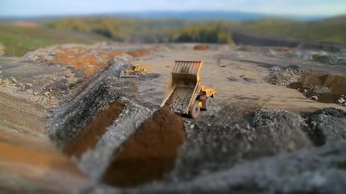 Tilt Shift Panorama Yellow Dump Truck Unloads Rocks and Gravel