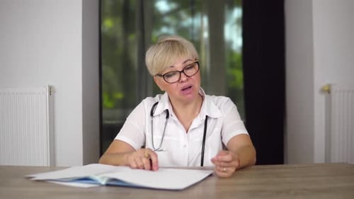 Una agradable doctora con corte de pelo corto y gafas está dando recomendaciones
