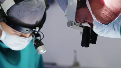 Surgeons Performing Operation with Headlamps in Hospital