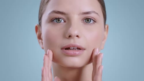 Close Up of Beautiful Woman Touching Her Face with Both Hands While Looking to Camera