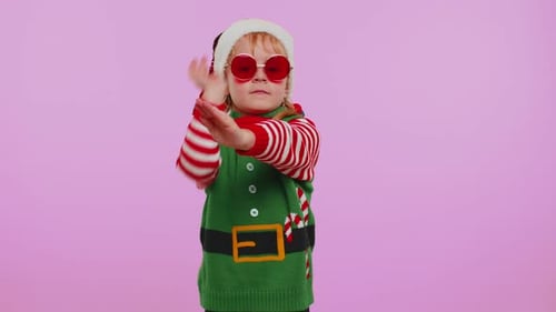 Festive Child Dancing in Elf Costume and Santa Hat