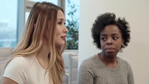 Three Women Talking Indoors in Bright Office Space