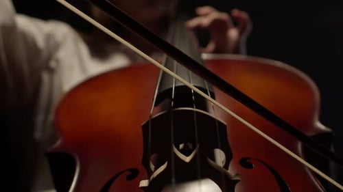 Cellist Playing Cello in Dark Setting