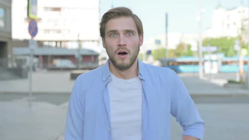 Man Reacts with Shock and Surprise on City Street