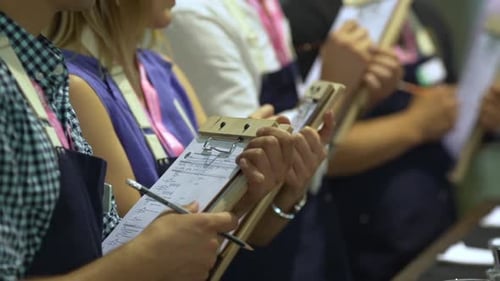Vidéo de Slomo montrant des personnes évaluant les participants à un festival du café en train de noter des informations sur