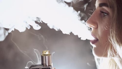 Chica joven con estilo en una ciudad con vape