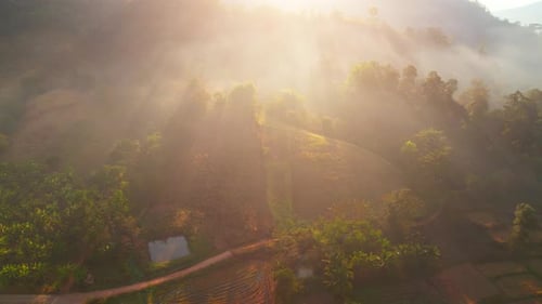 Aerial view over villages and barren fields in countryside during sunrise