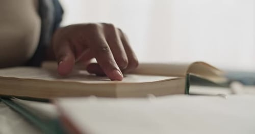 Woman Studying a Book Indoors at Desk