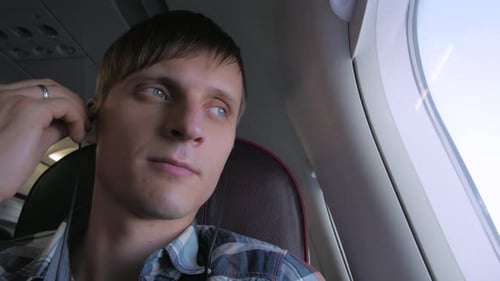 Young Man In Headphones On Airplane