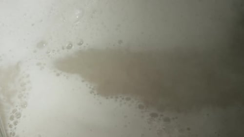 Paddle Stirring Bubbling Liquid in Metal Pot