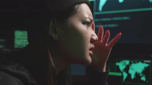Hacker asiática de cerca usando hackeo informático y molesto, Código en varias pantallas de computadora