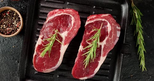 Raw Beef Steaks on Grill with Rosemary