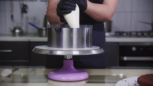 Konditorei eine Frau gießt Vanillecreme auf den Keks in der Form