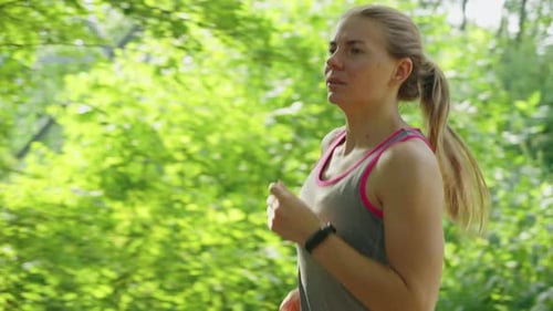 Fit Woman Jogging in Park in Slow Motion