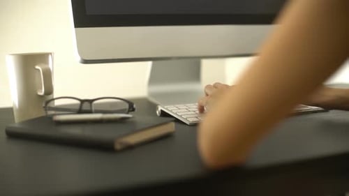 Hands Typing on Computer Keyboard at Desk