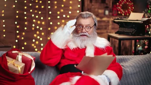 Santa Claus Reads a Letter on a Couch