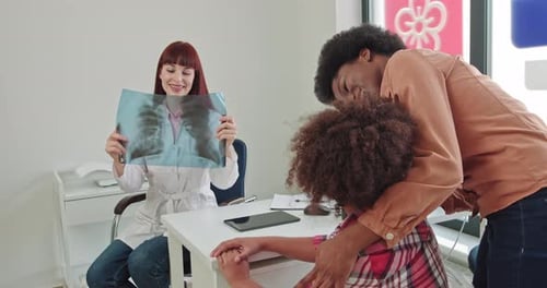 Doctor Holding X-Ray Consults with Family