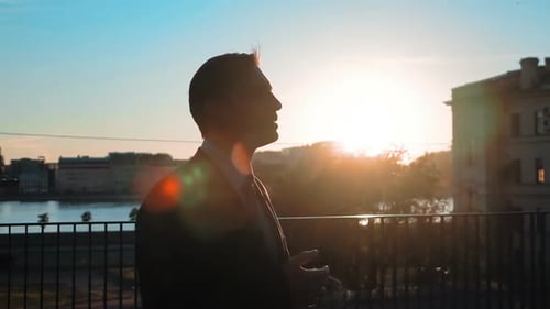 Man in Suit Talking at Sunrise in City