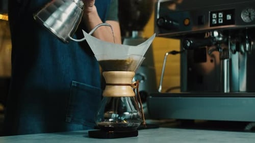 Person Prepares Pour Over Coffee in Cafe