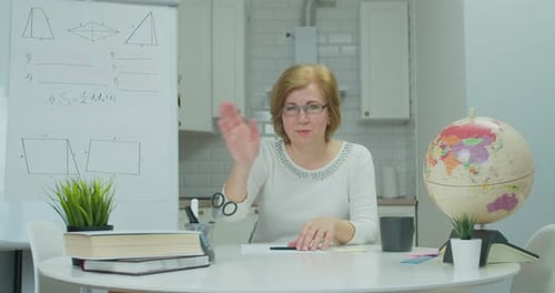 Woman Explains Math Lesson at Desk with Globe