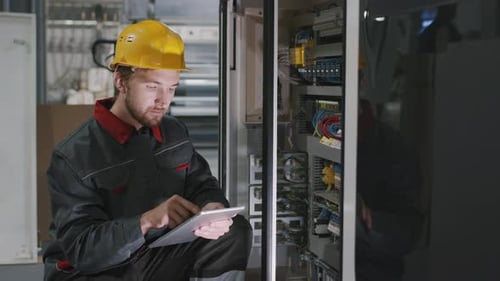Engineer Checking Electric Panel At Factory