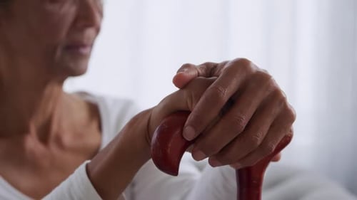 Senior Woman's Hands Resting on a Cane