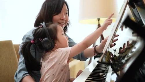 Young Girl Learning Piano with Woman at Home