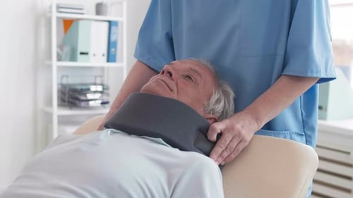 Medical Staff Applying Neck Brace to Senior Patient