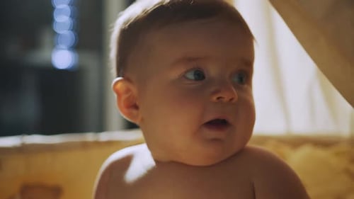 Curious Infant in Crib Looking Off To Side