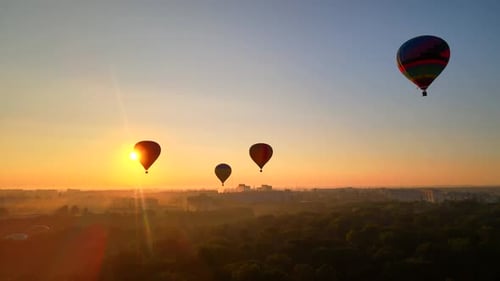 Aerial Drone HDR View of Colorful Hot Air Balloon Flying Over Green Park in Small European City at